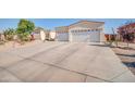 Spacious driveway leading to a three-car garage, highlighting the home's ample parking and curb appeal at 3125 W Desert Ln, Laveen, AZ 85339