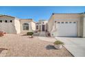 Charming single-story home featuring an arched entryway, desert landscaping, and an attached two-car garage at 3125 W Desert Ln, Laveen, AZ 85339