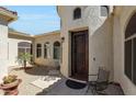 Close-up of front entrance with decorative door, desert landscaping and wrought iron seating at 3125 W Desert Ln, Laveen, AZ 85339