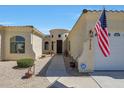Charming home featuring a decorative front door, elegant stonework, and a well-maintained walkway at 3125 W Desert Ln, Laveen, AZ 85339