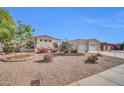 Charming home with a desert landscape, manicured greenery, and an attached three car garage at 3125 W Desert Ln, Laveen, AZ 85339