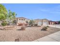 Well-maintained desert front yard displaying drought-resistant landscaping, including gravel, cacti and colorful flowering plants at 3125 W Desert Ln, Laveen, AZ 85339