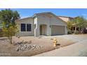 Beautifully landscaped single-story home with desert landscaping, a two-car garage, and a yellow fire hydrant at 43690 W Knauss Dr, Maricopa, AZ 85138