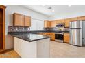 Well-lit kitchen showcasing granite countertops, stainless steel appliances, and tile backsplash at 45042 W Cypress Ln, Maricopa, AZ 85139
