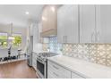 Modern kitchen featuring white cabinets, stainless steel appliances, and a stylish tile backsplash at 4700 S Fulton Ranch Blvd # 11, Chandler, AZ 85248