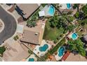 Aerial view of a neighborhood showcasing multiple homes with backyard pools and green landscaping at 6102 E Danbury Rd, Scottsdale, AZ 85254