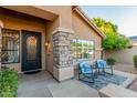 Cozy front porch with stone accents, rocking chairs, and stylish front door at 6918 W Villa Hermosa W --, Glendale, AZ 85310