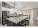 Stylish kitchen with gray island, granite countertops and white cabinetry at 6918 W Villa Hermosa W --, Glendale, AZ 85310