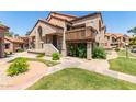Exterior view of a charming home with a terracotta roof and well-maintained landscaping and lush green grass at 700 E Mesquite Cir # O210, Tempe, AZ 85288