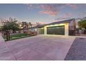Single-story house with a large driveway and garage, enhanced by modern architectural details at 720 E Chilton Dr, Tempe, AZ 85283