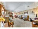 Cozy living room featuring carpeted floors, wood paneling, and comfortable furnishings at 7711 E Farmdale Ave, Mesa, AZ 85208
