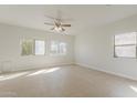 Generously sized bedroom with soft carpeting, a ceiling fan, and multiple windows offering ample natural light at 9939 W Southgate Ave, Tolleson, AZ 85353