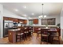 Spacious kitchen featuring stainless steel appliances and a granite countertop island with breakfast bar at 11253 E Peterson Ave, Mesa, AZ 85212