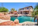 Expansive backyard features a pool, outdoor kitchen with bar, and a dining area, perfect for entertaining guests at 11965 W Monte Vista Rd, Avondale, AZ 85392