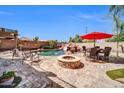 Gorgeous backyard pool with rock waterfall, fire pit, and outdoor dining area, creating a relaxing and inviting atmosphere at 11965 W Monte Vista Rd, Avondale, AZ 85392