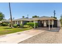 Inviting single-story home with a carport, well-manicured landscaping, and a long driveway at 1209 W Colter St, Phoenix, AZ 85013