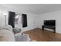 Living room featuring tiled floors, a large window, and a comfortable couch at 12123 W Bell Rd # 211, Surprise, AZ 85378