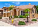 Charming two-story home featuring desert landscaping, mature palm trees, and a welcoming front entrance at 13324 W Annika Dr, Litchfield Park, AZ 85340