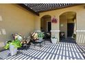Covered front porch featuring stone floors, comfortable seating, and decorative plants at 17516 W Glenhaven Dr, Goodyear, AZ 85338