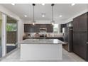 Modern kitchen featuring stainless steel appliances, a spacious island with pendant lighting, and sliding glass doors at 17721 W Cassia Way, Goodyear, AZ 85338