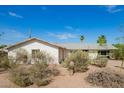 Single-story home with desert landscaping, under a clear blue sky at 1845 N 64Th St, Scottsdale, AZ 85257