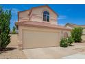 Two-story home with a two-car garage, desert landscaping, arched window and tile roof at 19230 N 5Th St, Phoenix, AZ 85024