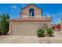 Two-story home with a two-car garage, desert landscaping and an arched window above at 19230 N 5Th St, Phoenix, AZ 85024