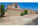 A tan home with a two-car garage, desert landscaping, and a stop sign in the yard at 19230 N 5Th St, Phoenix, AZ 85024