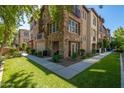Beautiful stone exterior of condo building with lush green lawn and mature landscaping on a sunny day at 2470 E Roma Ave, Phoenix, AZ 85016