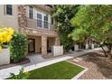 Charming condo exterior featuring stone accents, a private balcony, and well-manicured landscaping at 2470 E Roma Ave, Phoenix, AZ 85016