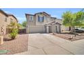 View of the home showing the two-car garage and landscaping at 25726 W Burgess Ln, Buckeye, AZ 85326