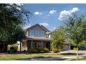 Inviting two-story home featuring a cozy front porch, manicured lawn, and vibrant yellow bushes at 3133 E Silo Dr, Gilbert, AZ 85296