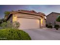 Two-car garage with a long driveway and desert landscaping in the front of the house at 3713 W Nancy Ln, Phoenix, AZ 85041