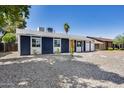 Single-story blue home with white trim, gravel landscaping, and a driveway leading to the garage at 3801 E Captain Dreyfus Ave, Phoenix, AZ 85032