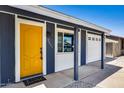 Close-up of the yellow front door with address, white trim, and adjacent garage at 3801 E Captain Dreyfus Ave, Phoenix, AZ 85032