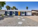 Landscaped front yard with gravel, concrete steppers, and a well-maintained blue house in the background at 3801 E Captain Dreyfus Ave, Phoenix, AZ 85032
