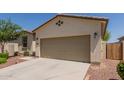 Two-car garage and desert landscaping offer a low-maintenance and practical exterior at 40066 W Jenna Ln, Maricopa, AZ 85138