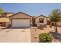 Single-story home with a two-car garage and desert landscaping at 41767 W Somerset Dr, Maricopa, AZ 85138