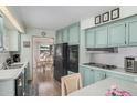 Kitchen featuring blue cabinets, modern black appliances, and open access to dining area at 506 S 81St Pl, Mesa, AZ 85208