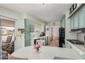 Bright kitchen featuring blue cabinetry, black appliances, and adjacent dining area at 506 S 81St Pl, Mesa, AZ 85208