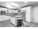 Bright kitchen featuring white cabinets, stainless steel appliances, an island, and sleek gray countertops at 540 Leisure World --, Mesa, AZ 85206