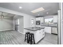An open kitchen with white cabinets, stainless steel appliances, a center island and modern gray flooring at 540 Leisure World --, Mesa, AZ 85206