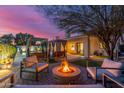 Inviting backyard with a fire pit, seating, cabanas, and access to the beautifully lit backyard at 6325 E Helm Dr, Scottsdale, AZ 85254