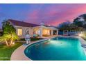 A refreshing backyard pool featuring shimmering water, unique hanging chairs, and a well-kept garden at 6325 E Helm Dr, Scottsdale, AZ 85254