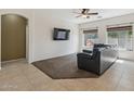Comfortable living room with a plush sectional, ceiling fan, and abundant natural light from large windows at 6425 S Kimberlee Way, Chandler, AZ 85249
