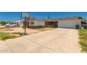 Exterior view of a single-story home with a long driveway and a basketball hoop in the front yard at 6541 N 41St Ave, Phoenix, AZ 85019
