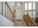 Bright foyer features a tiled floor, wooden staircase, white door, and large windows for natural light at 742 W Agrarian Hills Dr, San Tan Valley, AZ 85143