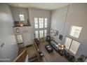 Open-concept living room features tall ceilings, large windows, a ceiling fan, and stairs to upper level at 742 W Agrarian Hills Dr, San Tan Valley, AZ 85143