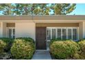 Home's front entrance with well-manicured bushes and a secure screen door, offering curb appeal and enhanced security at 7740 E Heatherbrae Ave # 3, Scottsdale, AZ 85251