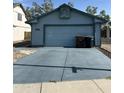 Exterior shot of garage with two car spaces, blue exterior paint and long driveway at 8155 W Desert Cove Ave, Peoria, AZ 85345